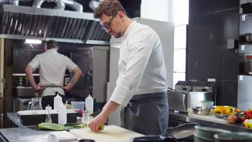 Chef Cutting Leeks in Restaurant Kitchen