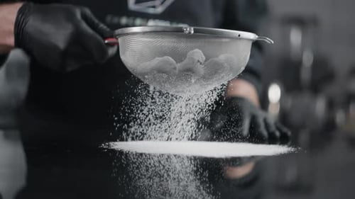 Chef Sieving Confectioners Sugar in the Kitchen