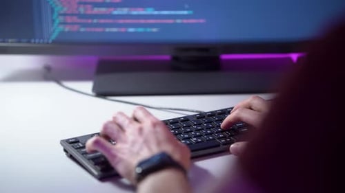 Visão macro das mãos do homem que está digitando no teclado e codificando um programa em um computador