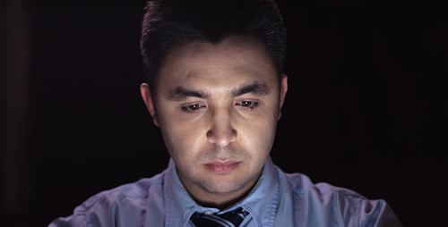 Man Works on Laptop at Night