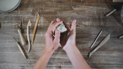 Person works with clay in workshop