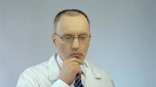 Mature Doctor Thinking with Finger on Chin