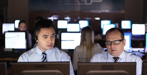 People Working at Computers in a Busy Office