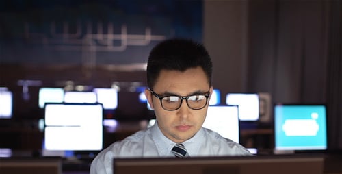 Man working in brightly lit office at night