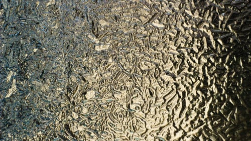 Ice Crystals Spreading Abstractly on Window Close Up