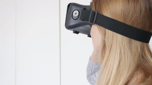 Blonde woman at home trying virtual reality 360 glasses 4K 2160p 30fps UltraHD footage - Blond femal