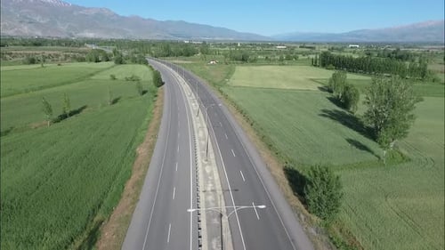 Vol Aérien sous une route vide à travers un paysage vert