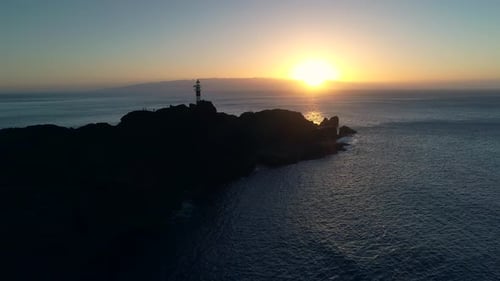 Coastal Island Lighthouse Silhouette at Golden Hour