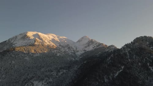 Luftaufnahmen mit einer Drohne von einem Berg voller Schnee. Berge und Bäume, Winter.