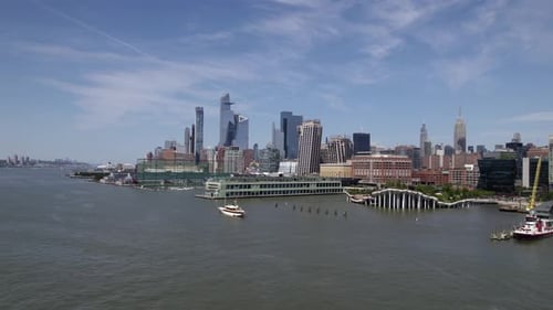Aerial view of Hudson yards and Chelsea piers, in sunny Midtown, NYC, USA - low, tracking, drone sho