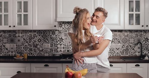 Affectionate Couple Embracing in the Kitchen at Home
