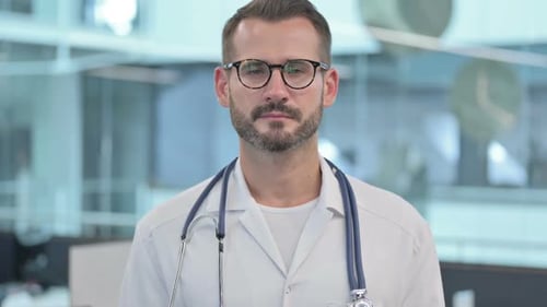 Stern Doctor with Stethoscope Looks Directly at Camera