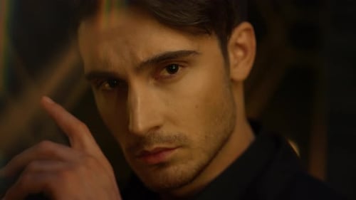 Thoughtful Man Keeping Finger Eyebrow Indoors. Serious Guy Looking Camera.