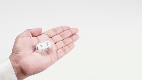 Hand Holding a Die with Numbers One Through Six