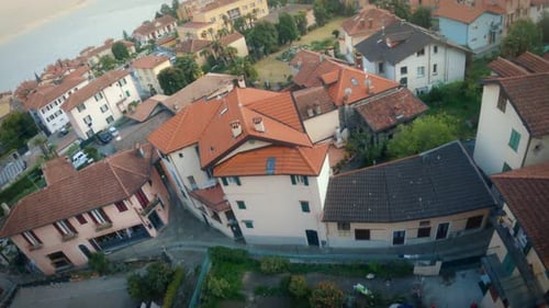 FPV drone shot over an Italian city near the coast, flying over houses, streets, around bell tower a