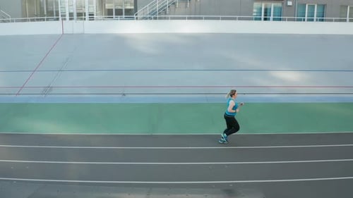 Woman Runs on an Urban Track