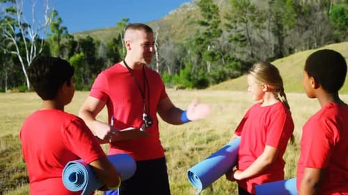 Entraîneur masculin interagissant avec les enfants dans le camp d'entraînement 4k