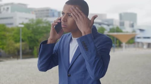 Worried Man Talking on Phone in Urban Setting