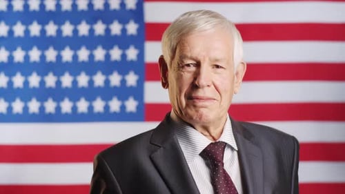Senior Man in Suit Posing By American Flag