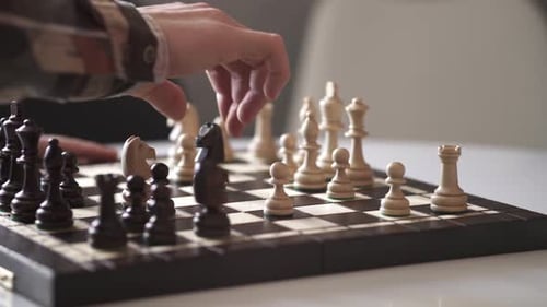 Ein Schachspieler macht einen Zug mit einem Ritter in Schachfigur.