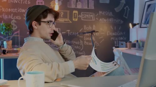 Young Adult Talking on Phone at Creative Office