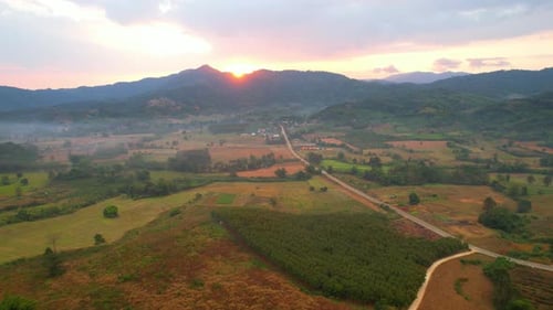 Aerial view from a drone over a misty landscape that covers the farmland