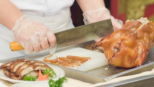 Chef Cuts Roasted Duck with Cleaver in Restaurant