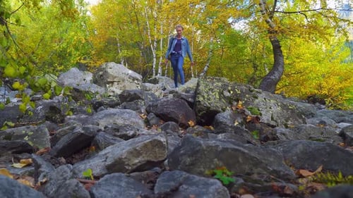Woman Hiking Rocky Trail in Autumn Landscape