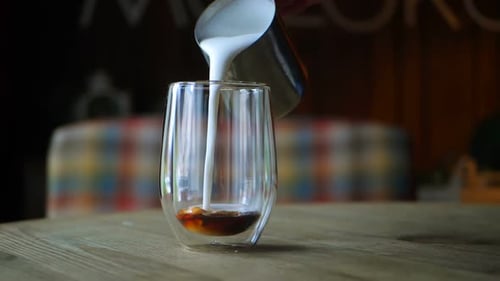 Milk Being Poured into Coffee in Glass