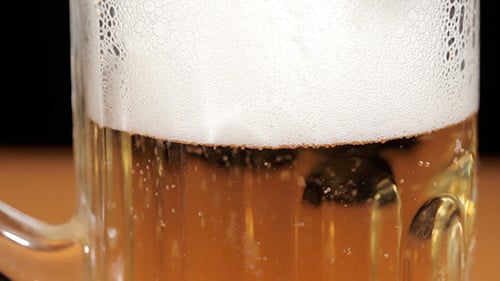 Close Up of Bubbly Beer with White Foam
