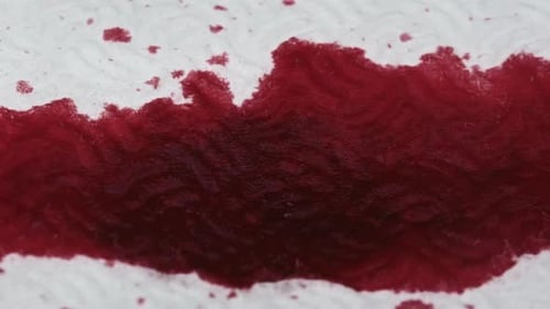 Spreading Red Liquid on Textured White Surface