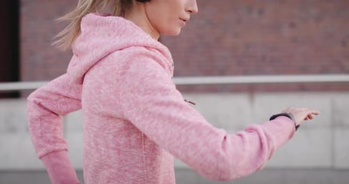 Tilt up video shows of jogging woman in the city