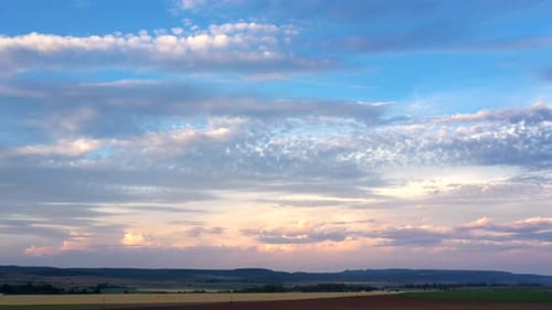 Picturesque Sunset Over Rural Farmland with Blue Sky