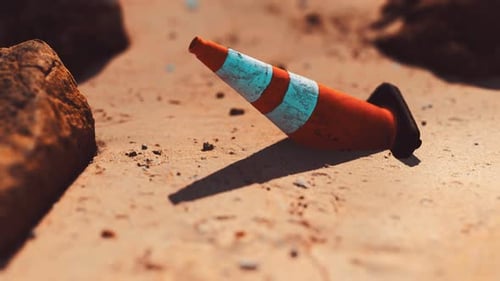 Cono de seguridad vial en una playa de arena vacía