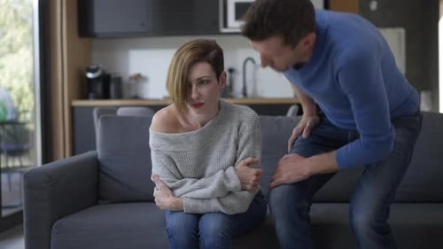 Upset Woman Being Comforted by Man on Couch