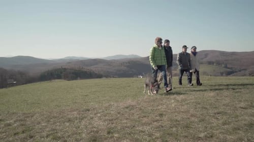 Four Active Seniors Walking Over Meadow to Bench