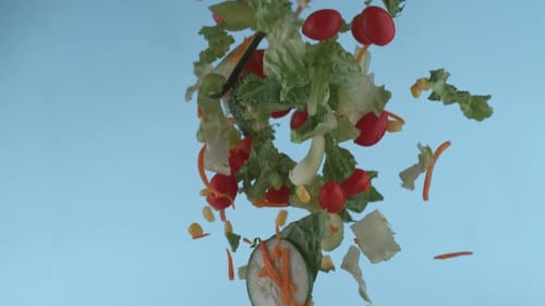 Fresh Vegetables Falling in Slow Motion on Blue