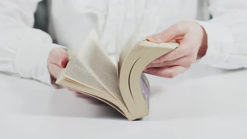 Hands Quickly Turning Pages in a Book