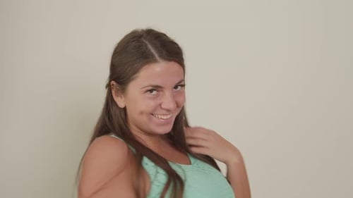 Smiling Woman Runs Fingers Through Brown Hair