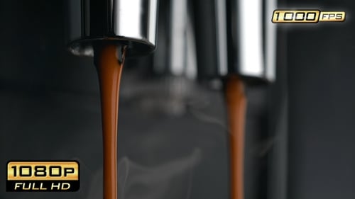 Espresso pours from spouts of coffee machine