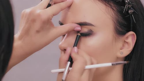 Makeup Artist Applying Eyeshadow to Model