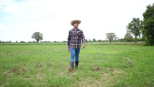 Young Adult Walking Through Green Farmland Field