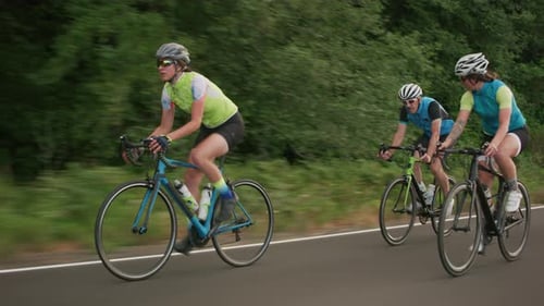 Tracking-Aufnahme einer Gruppe von Radfahrern auf einer Landstraße. Vollständig für den kommerziell Gebrauch freigegeben.