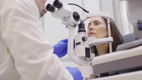 Eye Care Specialist Examining Retina of Female Patient with Slit Lamp