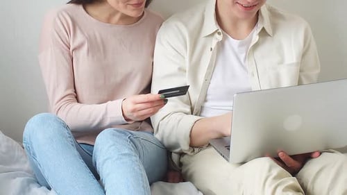 Couple shops online with laptop and credit card