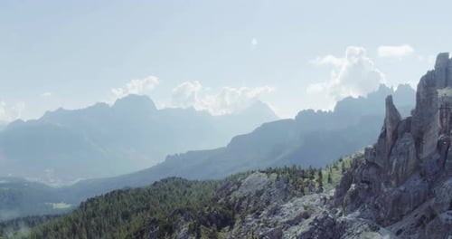 Aerial Flight Above Mountain Top with Pines and Rocks in Sunny Day