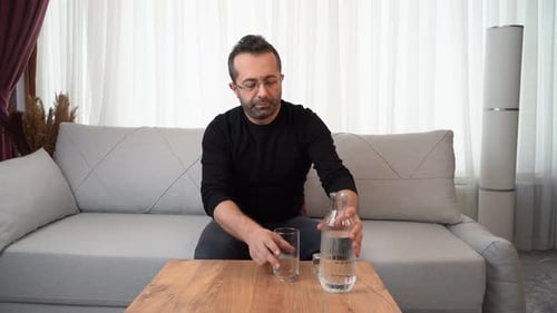 Man drinking water at home.