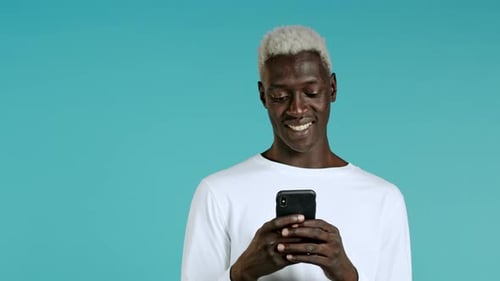 Handsome Black Man Receives Happy Notification on Mobile Phone. Guy Is Beside Himself with Surprise