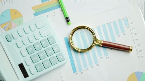 Documents with Magnifying Glass and Calculator