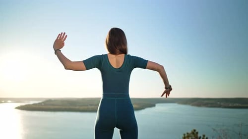 Woman Practicing in Gomukhasana Cow Head Pose Yoga on High Mountain Above Water